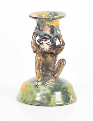 A Figural Pottery Candlestick 
20th century, with a monkey form shaft and a mottled 