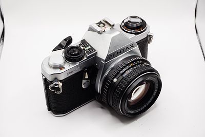 A Pentax me super 50mm f1.7. 35mm film SLR camera and lens combo, praised for its portability 