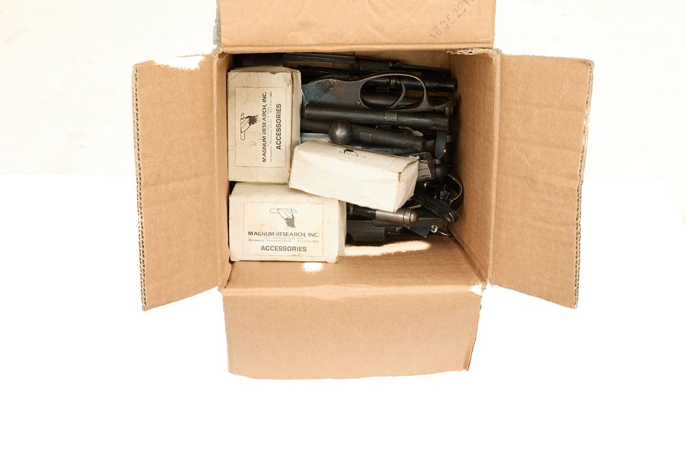 Lot 249: A box of assorted bolts, actions and spare parts.