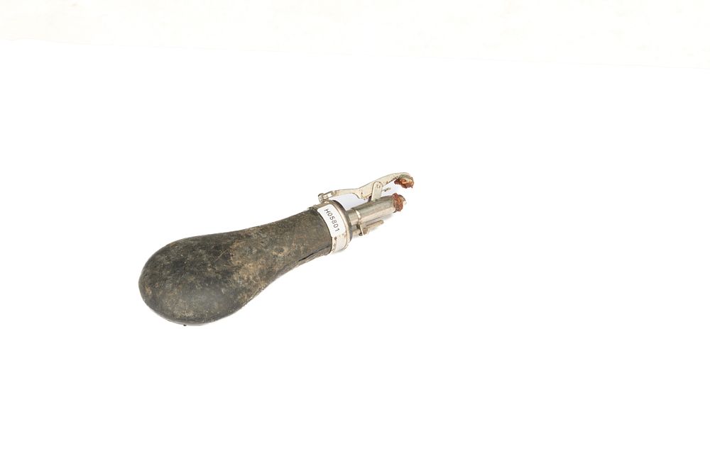 Lot 532: AN UNUSUAL PARKER HALE BIRMINGHAM ADJUSTABLE POWDER FLASK. WHITE METAL TOP, LEATHER COVERED BODY. BROKEN SPRING. WELL WORTH RESTORATION. GRADE 2.