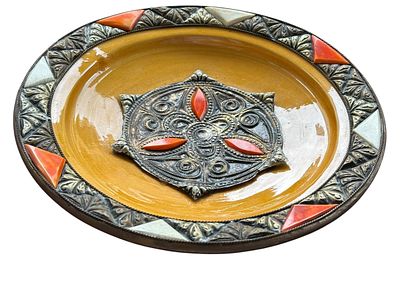 צלחת דקורטיבית מקרמיקה מזוגגת בגוון חום-כתום, עם מדליון מרכזי ושוליים ממתכת חרוטה, משובצים 