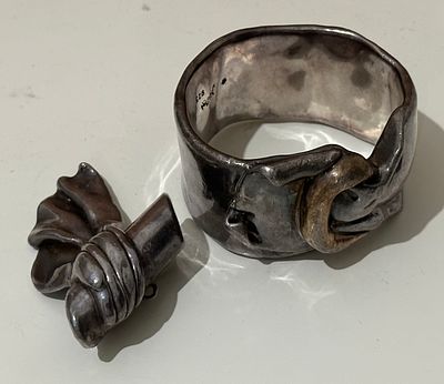 סט הכולל צמיד קשיח וסיכה, עשויים כסף 925, בעיצוב אורגני ופיסולי.
עבודת יד בסגנון אקספרסיבי, עם 