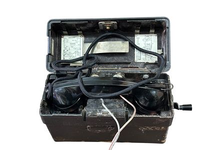 טלפון שדה ישן, קופסת בקאליט שחורה, כולל שפופרת, ידית סיבוב צדדית, כבל בד וחוטי חיבור שקופים. 