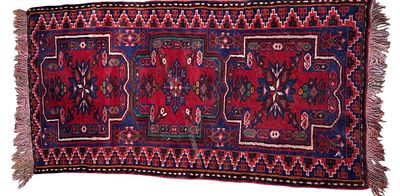 שטיח דקורטיבי בעבודת יד בסגנון אוריינטלי/שבטי, עם דוגמאות גיאומטריות מסורתיות בגווני אדום, כחול 