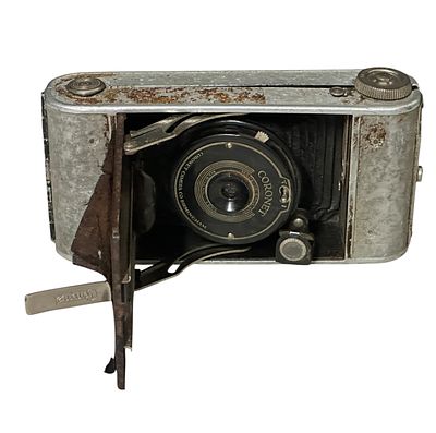 מצלמה מתקפלת עתיקה מתוצרת Coronet (אנגליה, Birmingham). גוף מתכתי עם מפוח נשלף ועדשת Coronet 