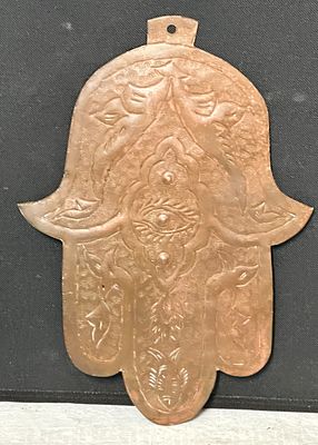 חמסה גדולה בסגנון אוריינטלי מנחושת, עבודת יד עם עיטור בתבליט הכולל עין מרכזית ודגמים מעוצבים. 