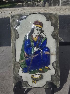 אריח פרסי עתיק בתלת מימד עשוי בציור עם זיגוג בתנור מהמם ביופיו ומיוחד בדמות איכרית פרסית אוחז 