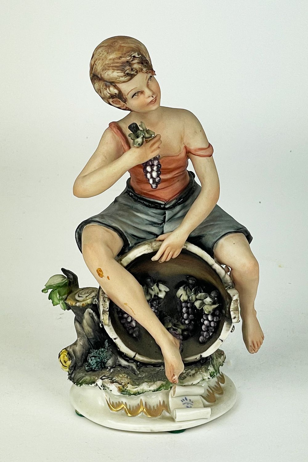 Polychrome artistic porcelain marked Capodimonte.
The sculpture depicts a boy in humble 