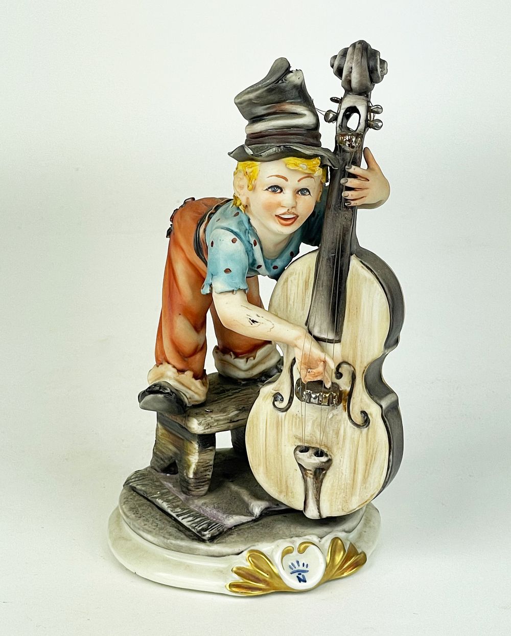 This polychrome artistic porcelain, bearing the Capodimonte mark, depicts a boy in humble 