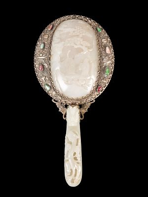 A JADE MIRROR. h cm 26,4With a pierced relief dragon decoration on the handle and a low-relief 