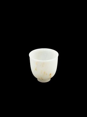 A WHITE AND RUSSETT JADE CUP. h cm 6,6Supported on a short straight foot, the plain sides 