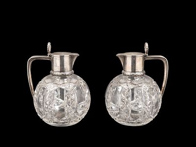 Faberg&egrave;
A PAIR OF CRYSTAL AND SILVER JUGS, Russia, 1908–1917. h cm 19.The globular body in 