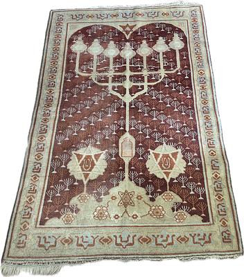 שטיח יודאיקה עבודת יד במרכז מנורה בסגנון מנורת המקדש יתכן שעהשטיח עבודת בצלאל אך לא בטוח