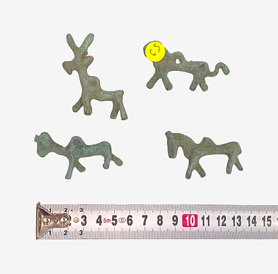 פסלוני חיות עתיקים מברונזה עם פטינה ירוקה וסרט מדידה – ממצאים ארכאולוגיים. ארבעה פסלוני חיות 