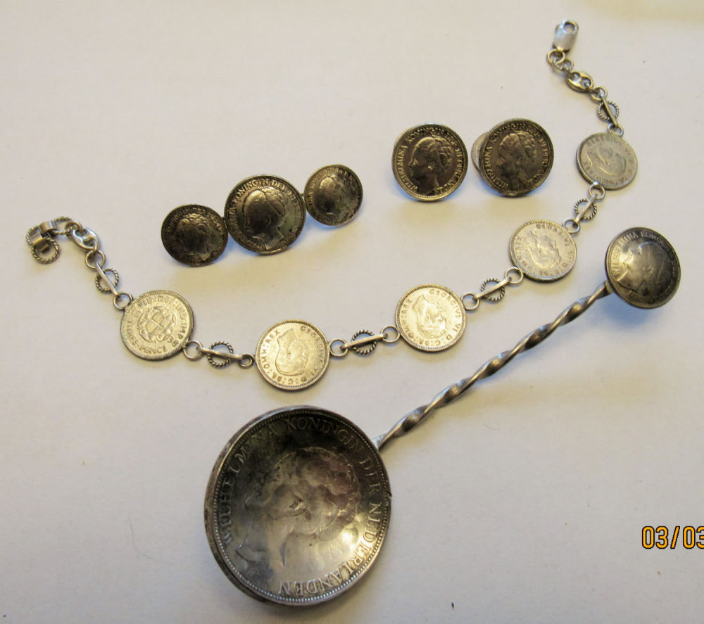 Lot 195: GROUPING OF WW11 SWEETHEART/TRENCH ART ITEMS. BRACELET IS STERLING SILVER AND 8.5" LONG. COINS CONTAINING VARIOUS SILVER CONTENT. ALL FOR ONE BID.