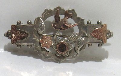 VICTORIAN STERLING SILVER WITH 9KT GOLD OVERLAY BROOCH.