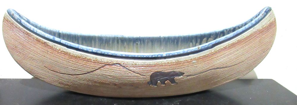 Lot 609: BUY-IT-NOW PRICE $100. STUNNING LARGE STUDIO POTTERY CANOE SIGNED ALLAN PACE. POLAR BEAR DECORATION ON BOTH SIDES. 21" OVERALL LENGTH