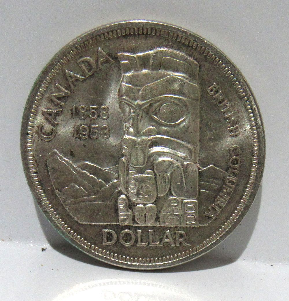 Lot 642: BUY-IT-NOW $75. 1958 SILVER CANADIAN DOLLAR TOTEM POLE.