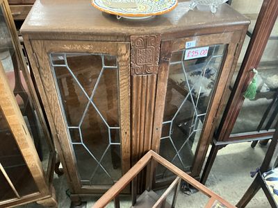An early 20th-century oak display cabinet with leaded glass doors