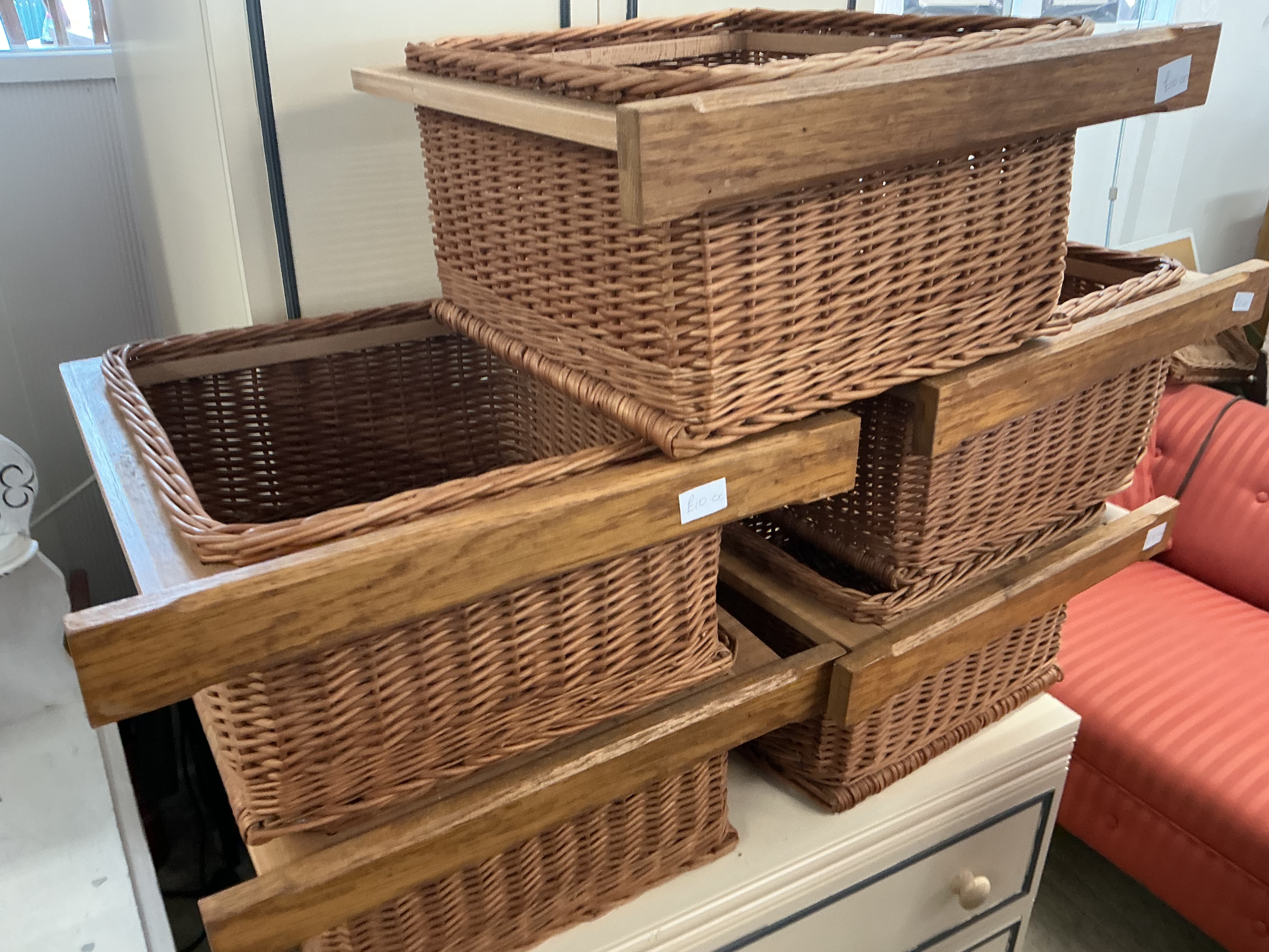 A Collection of Woven Wicker Storage Baskets with Wooden Runners