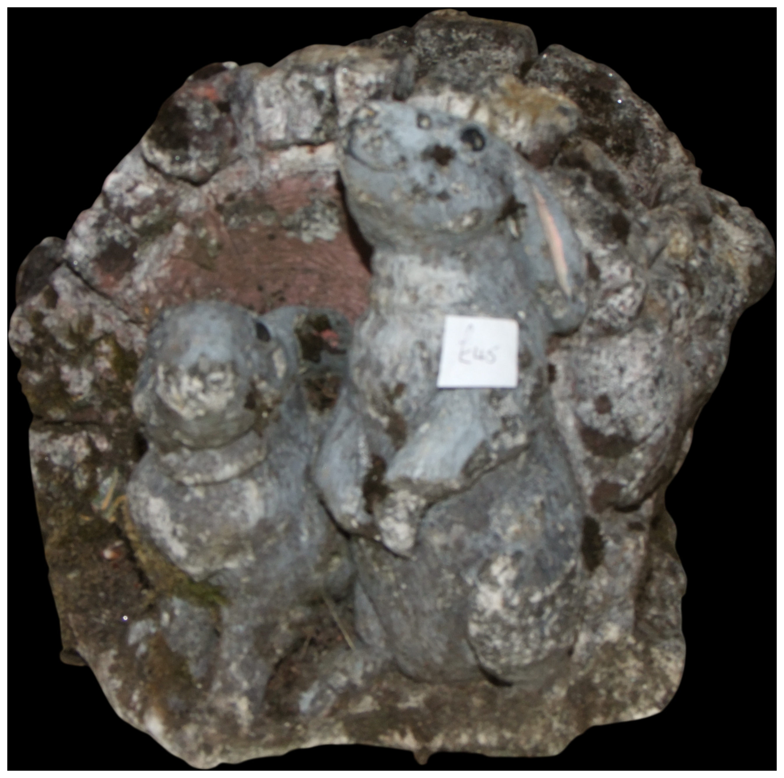 Two weathered cast stone rabbit garden ornaments