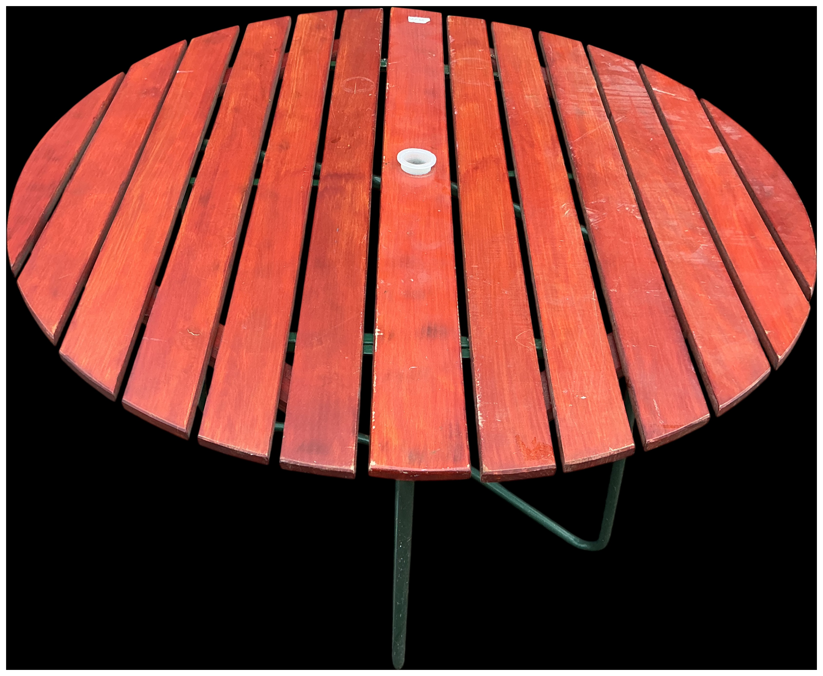 A circular slatted wood garden dining table in the style of Grythyttan
