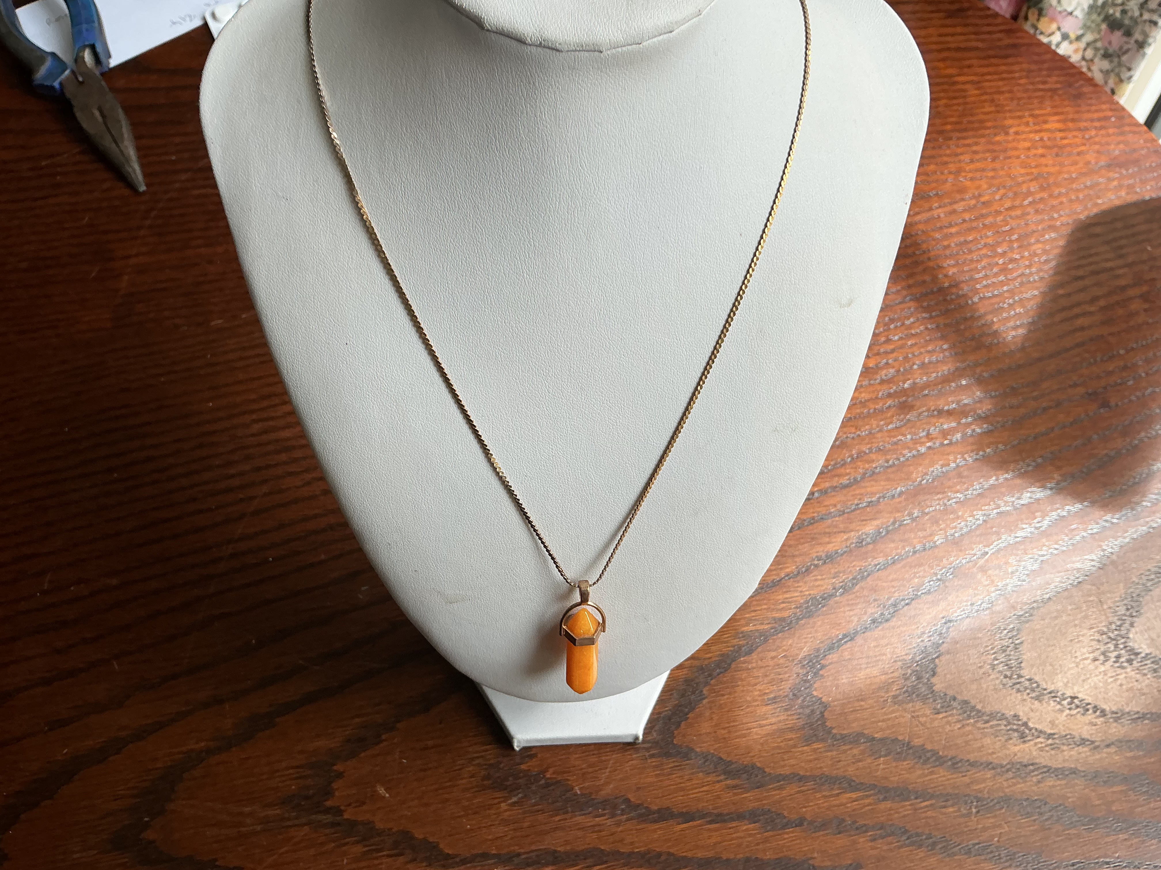 November. A Yellow Metal Chain Necklace with a Faceted Orange Hardstone Bullet Pendant