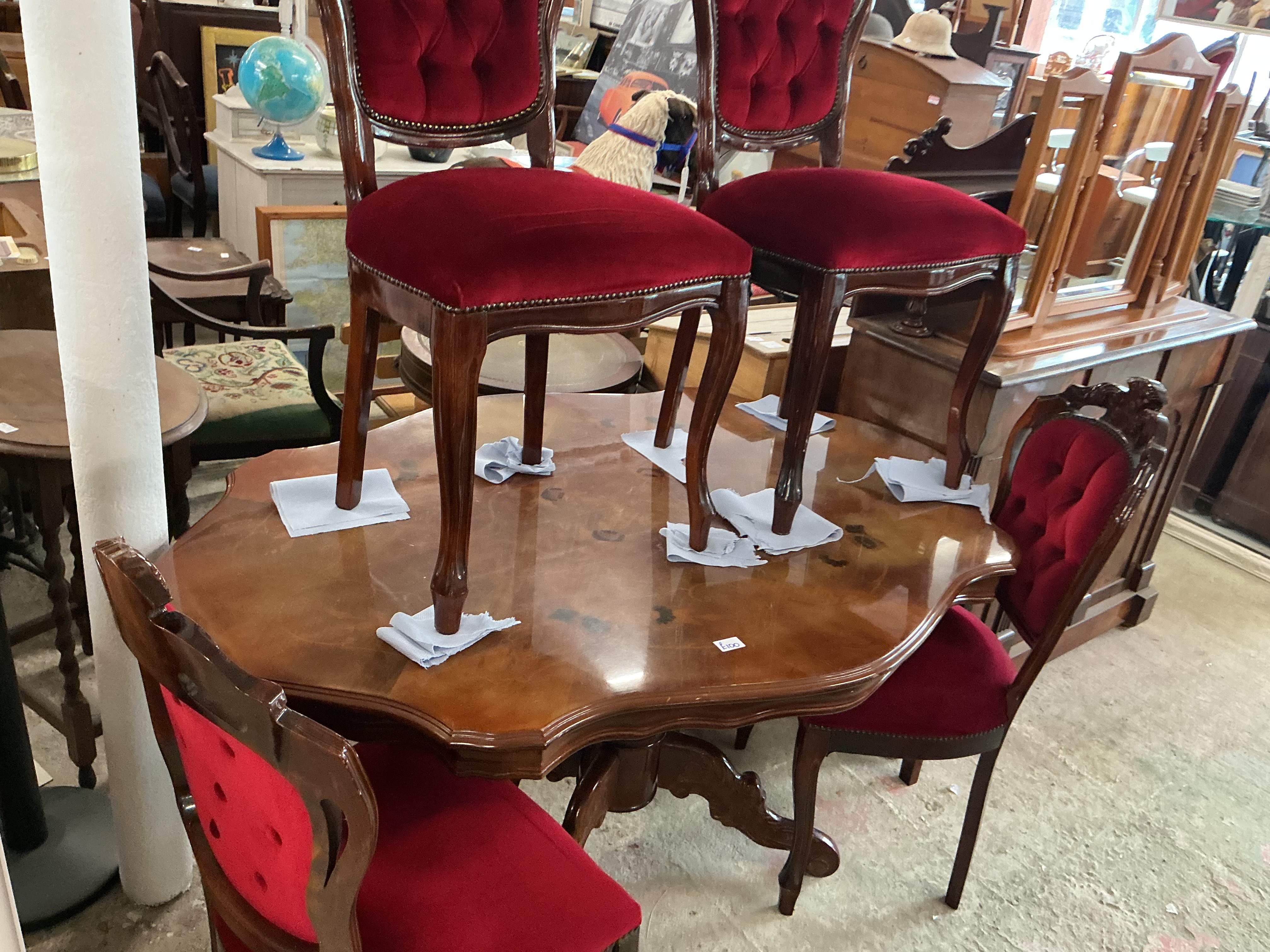 A Victorian Style Burr Walnut Veneered Dining Suite Comprising a Pedestal Table and Four Matching Red Velvet Upholstered Balloon Back Chairs