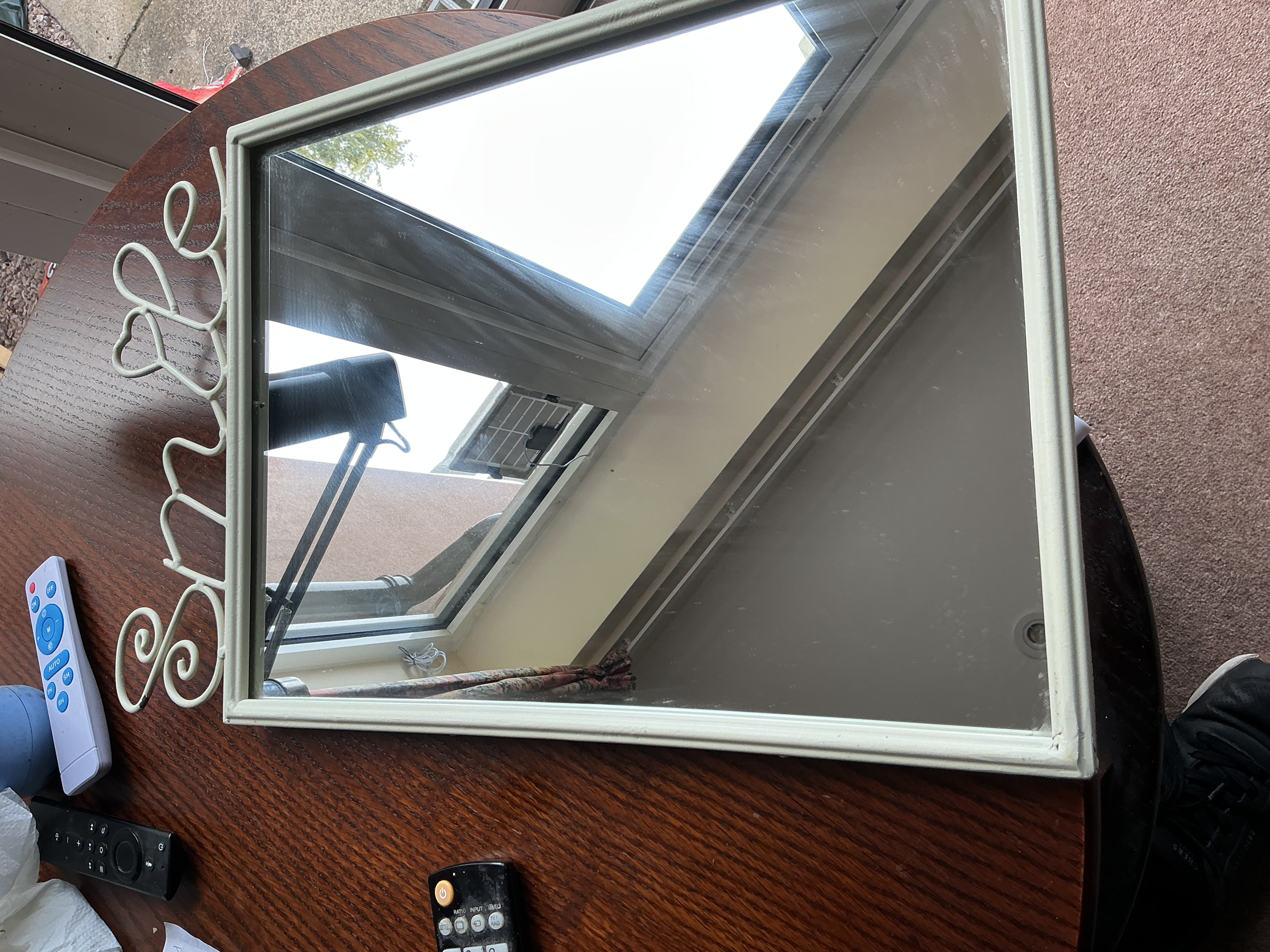 A Contemporary Cream Painted Metal Wall Mirror with Integrated Smile Wirework