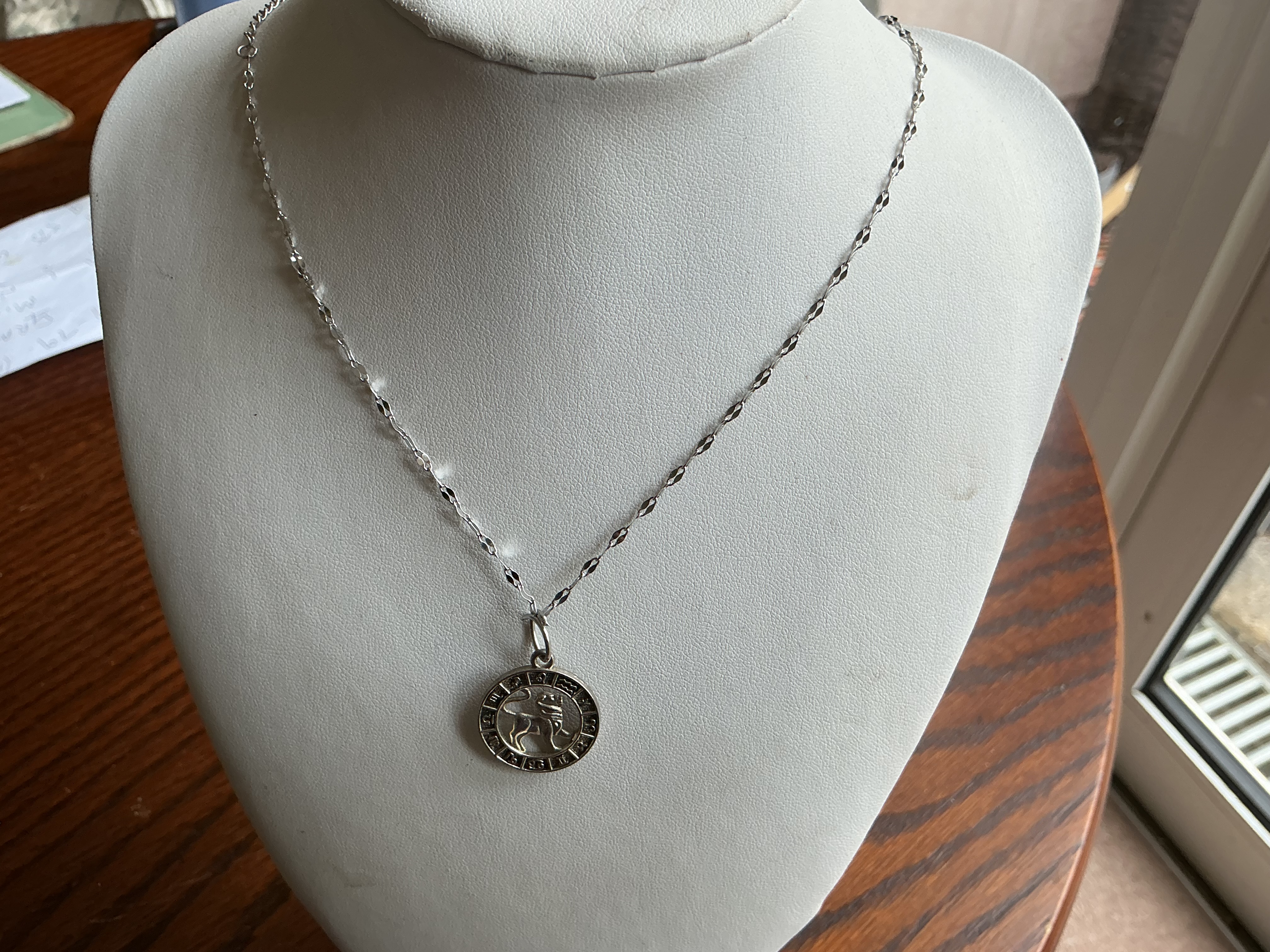 Leo A white metal zodiac medallion pendant necklace featuring a central Leo motif