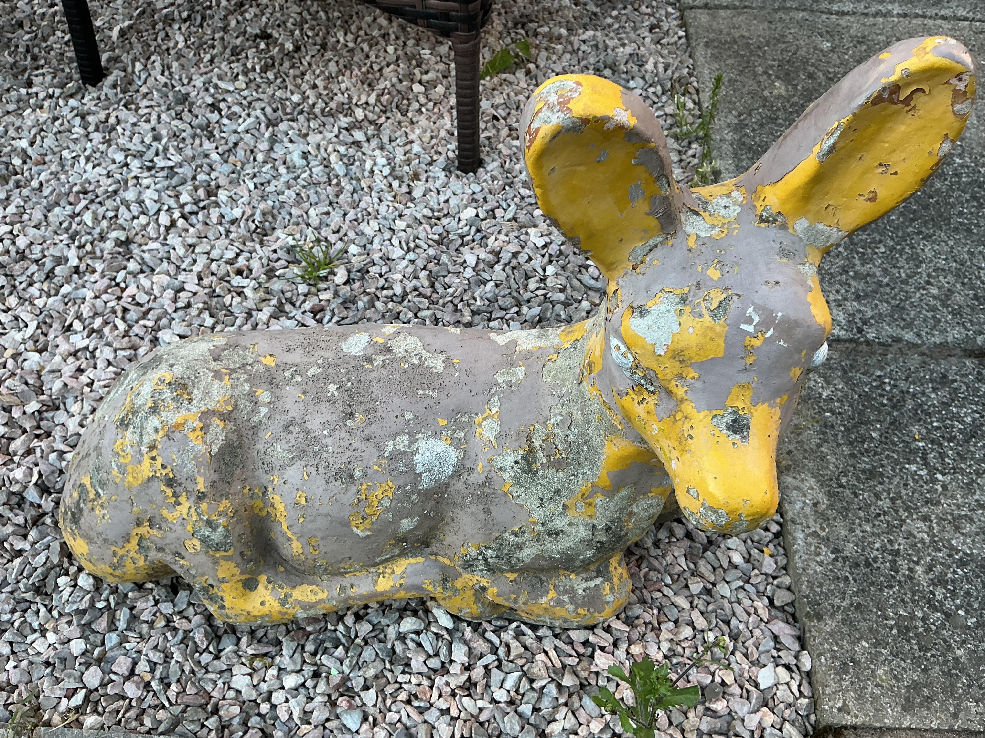 A vintage reconstituted stone garden sculpture of a recumbent fawn
