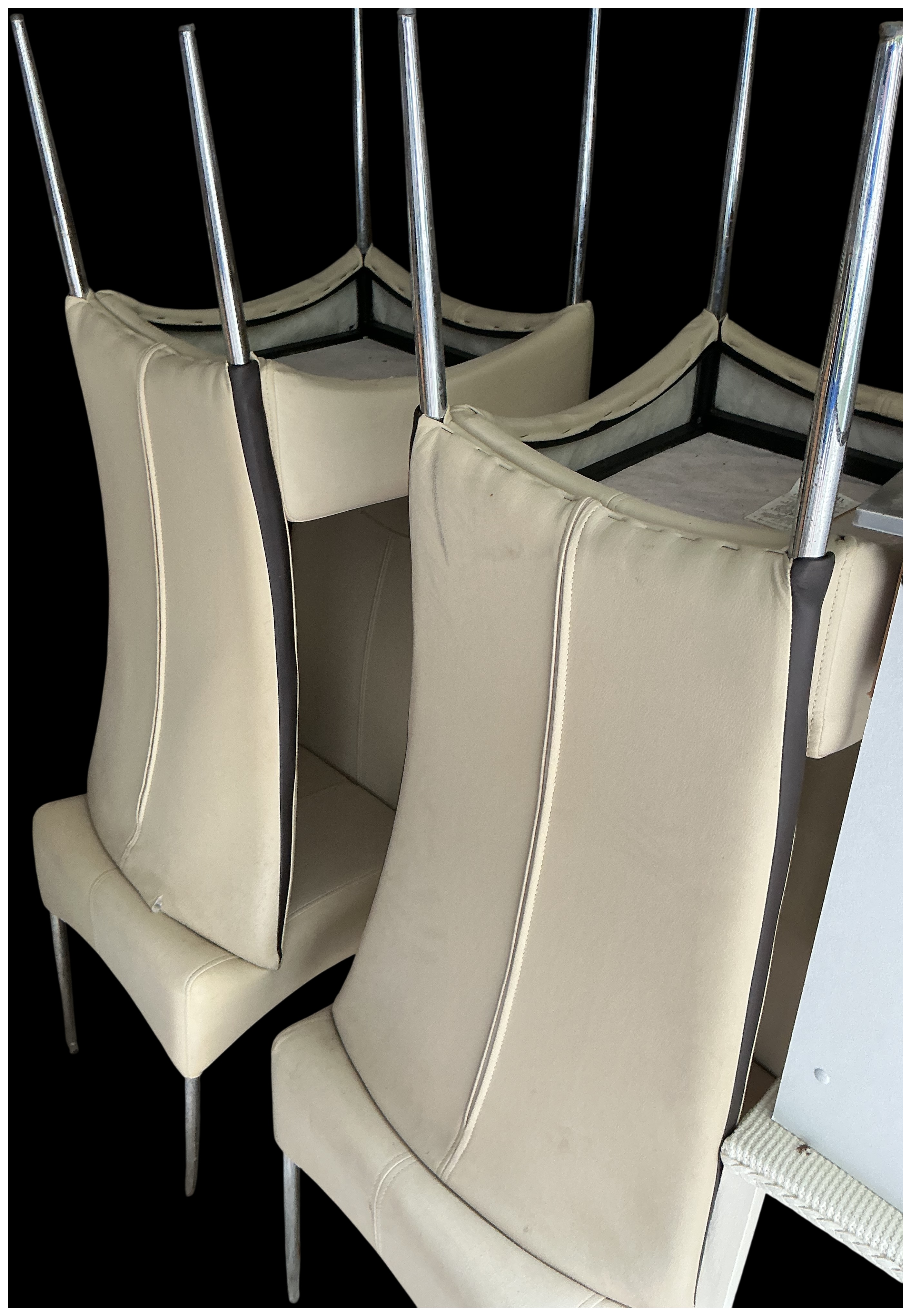 A set of four contemporary cream faux leather cantilever dining chairs with chrome frames