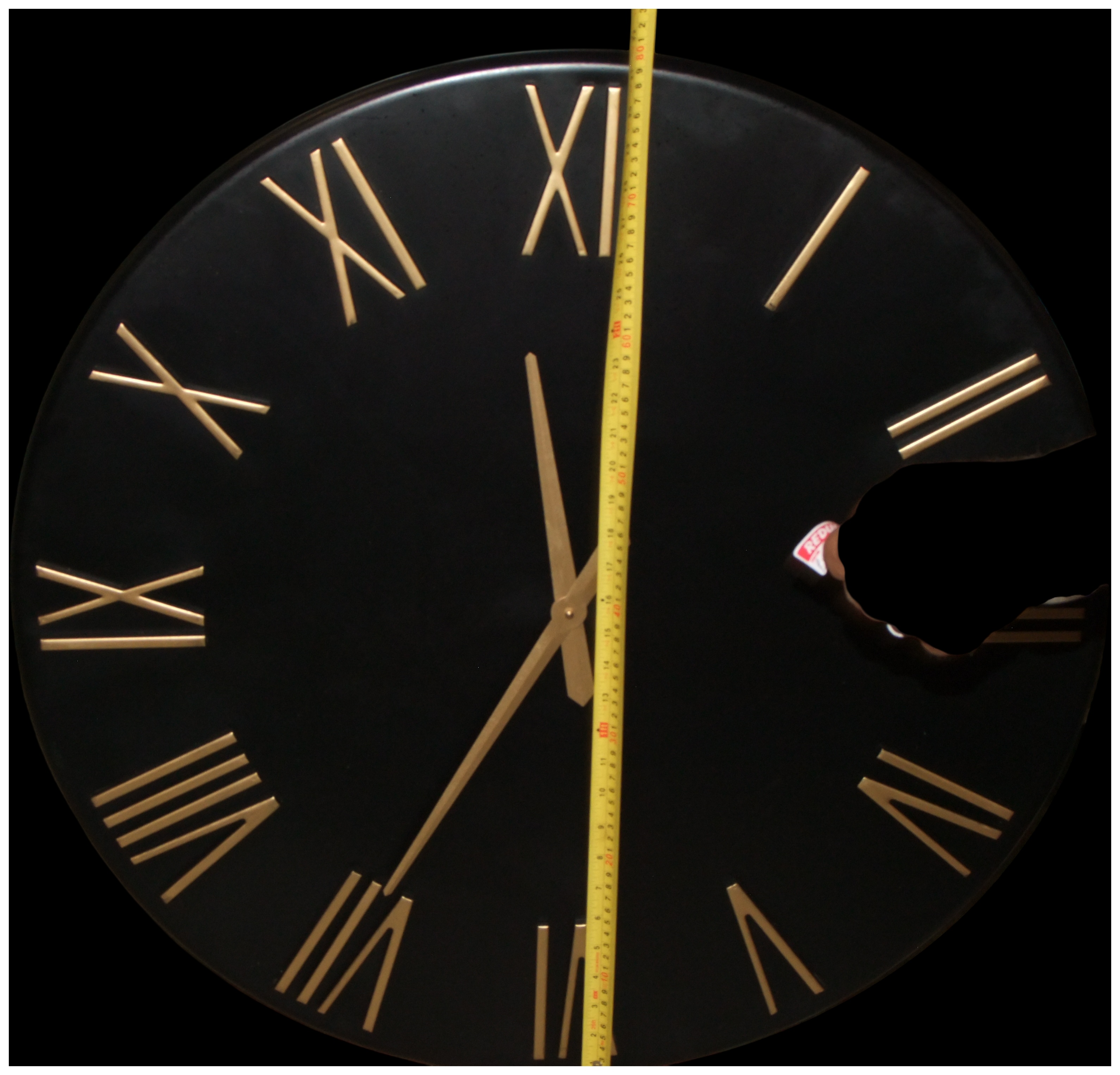 A Large Contemporary Black Metal Circular Wall Clock with Gold Tone Roman Numerals