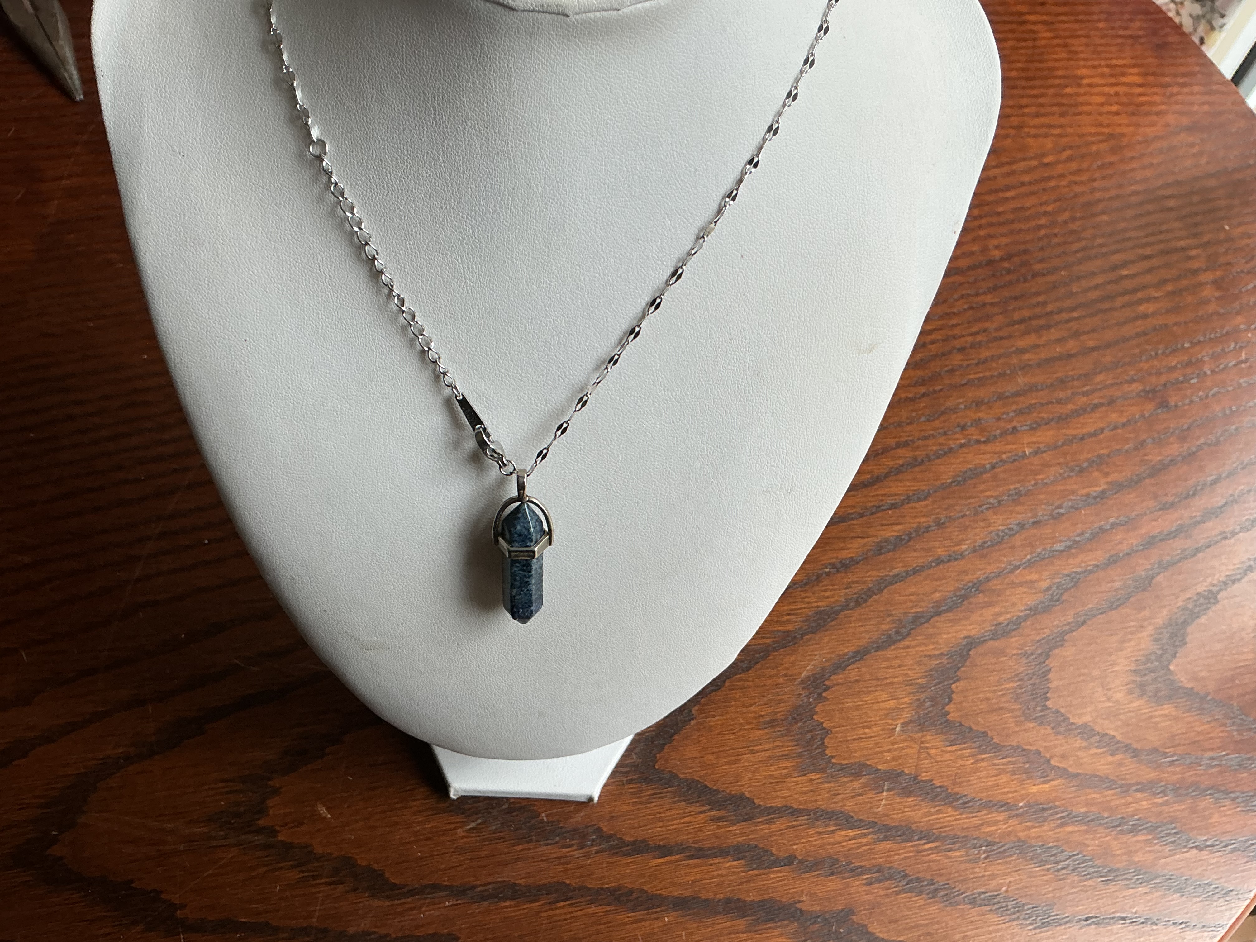 December. A contemporary silver-tone necklace with a mottled blue gemstone point pendant
