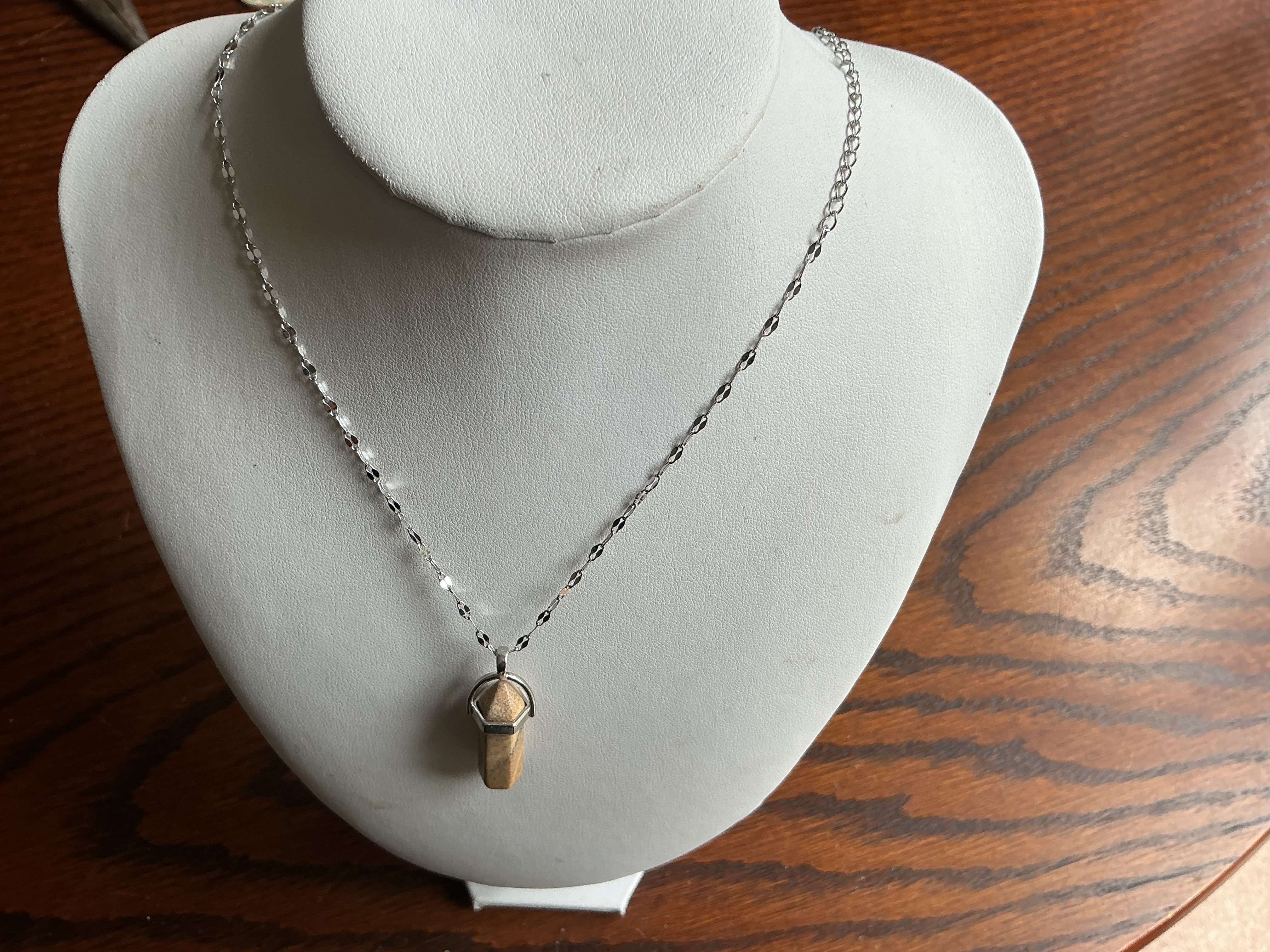 June. A banded stone hexagonal point pendant on a silver-tone faceted link chain