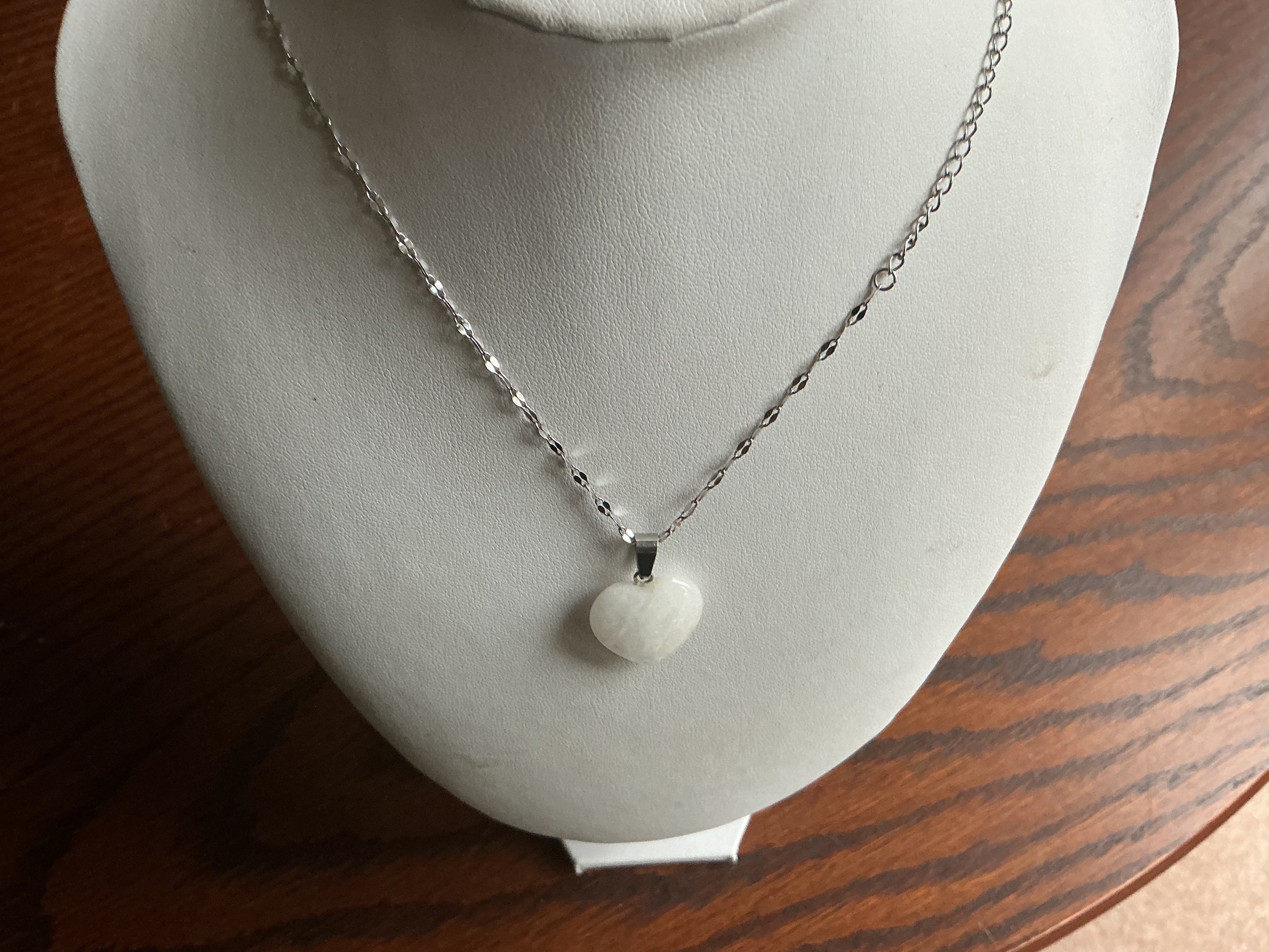 April. A Silver-Toned Heart-Shaped White Stone Pendant Necklace