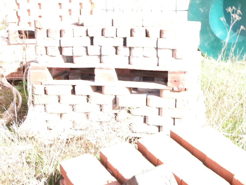 Lot 84: A Collection of Red Clay Building Bricks on Wooden Pallets