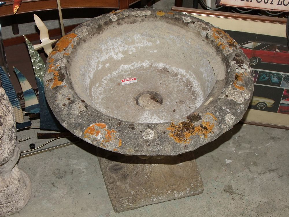 Lot 37: A weathered cast stone garden urn of campana form on a plinth base