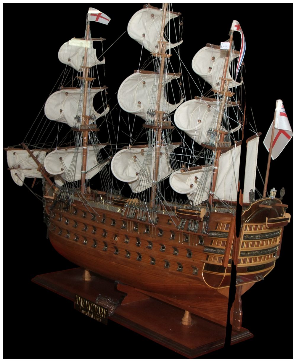 Lot 177: A large-scale wooden model of HMS Victory in a glass display case. No reserve.