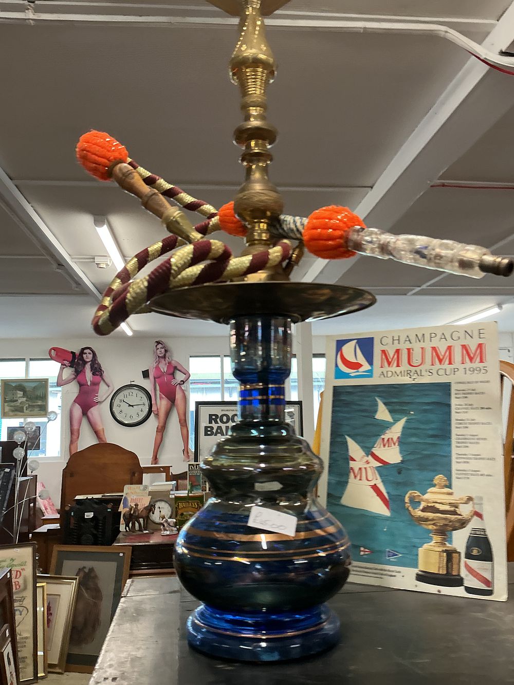 Lot 373: A contemporary Middle Eastern style hookah pipe with a blue glass base and brass-toned metal stem