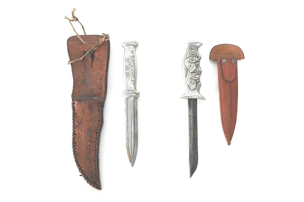 Lot 217: (2) WWII Theater Knives Engraved Handles Leather Sheaths
