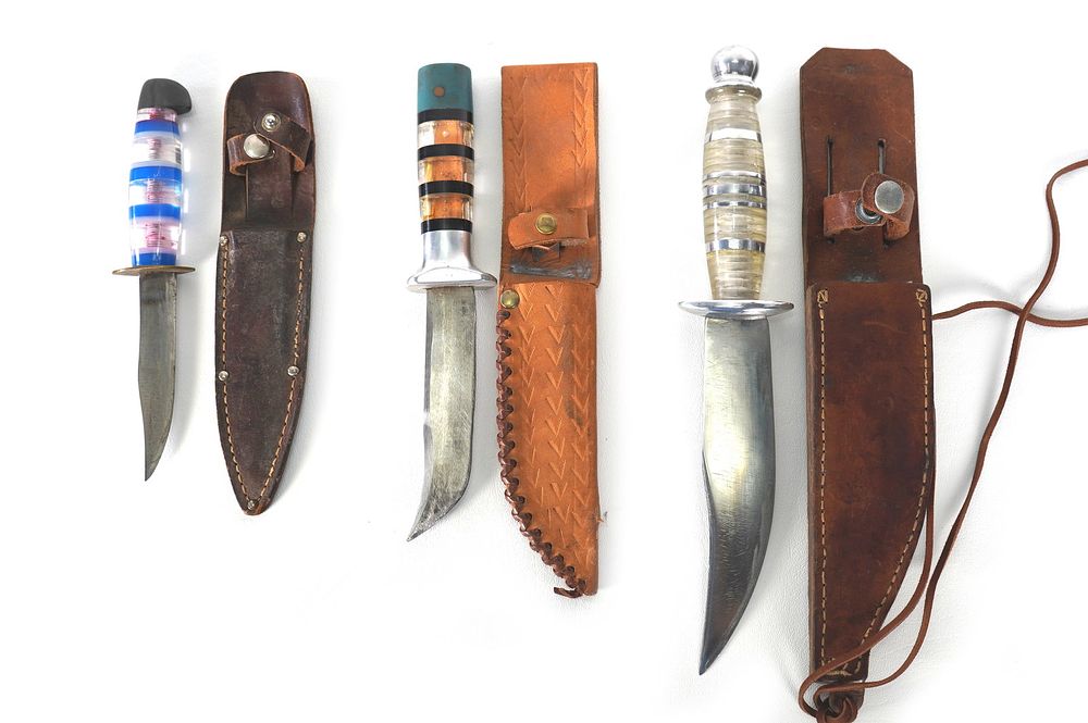 Lot 225: (3) WWII Plexiglass Handled Theater Knives w/Leather Sheaths