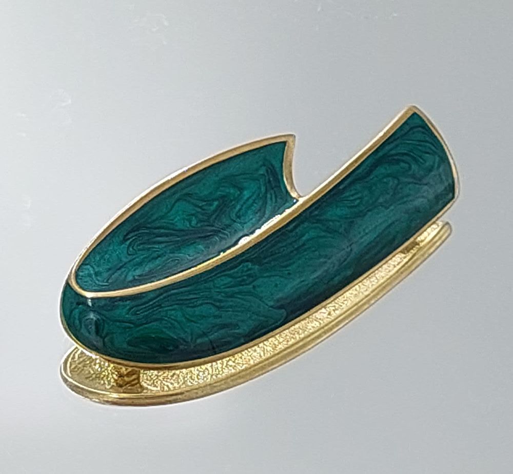 Enamel pin. Length: 6 cm 
Width: 3 cm 
Gilt 
As new
