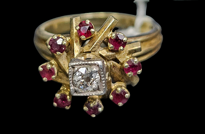 טבעת מזהב 14 קראט משובצת יהלום כ 70 נקודות ו 8 רובינים , 
משקל הטבעת 6.53 גרם מידת הטבעת 7.5 ,