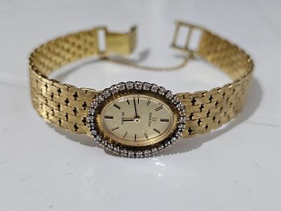 שעון לנשים אומגה מזהב 18 קראט ויהלומים מסביב משקל השעון 42 גרם קוטר השעון 20 ס'ממשקל השעון 42 גרם