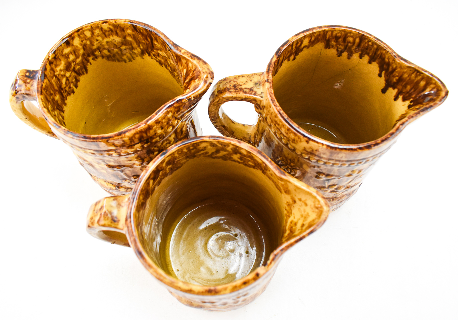 THREE AMERICAN 'PEACOCK AND PALM TREE' ROCKINGHAM STYLE PITCHERS