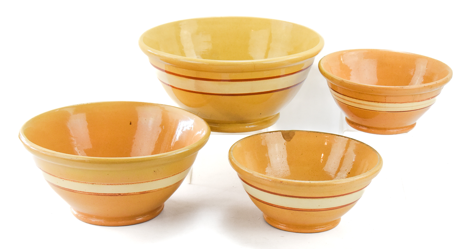FOUR RED-AND-WHITE BANDED YELLOW WARE BOWLS
