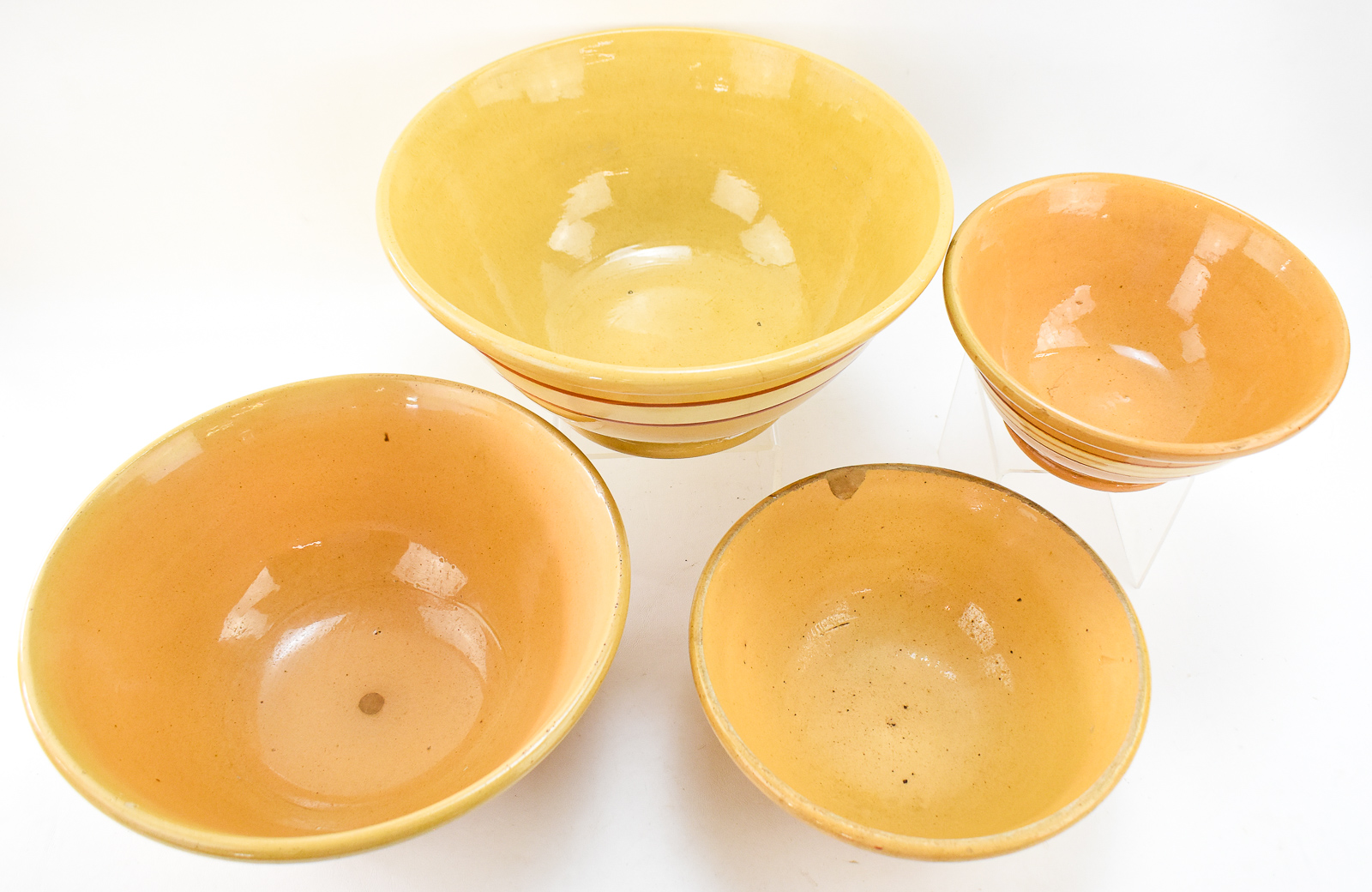 FOUR RED-AND-WHITE BANDED YELLOW WARE BOWLS