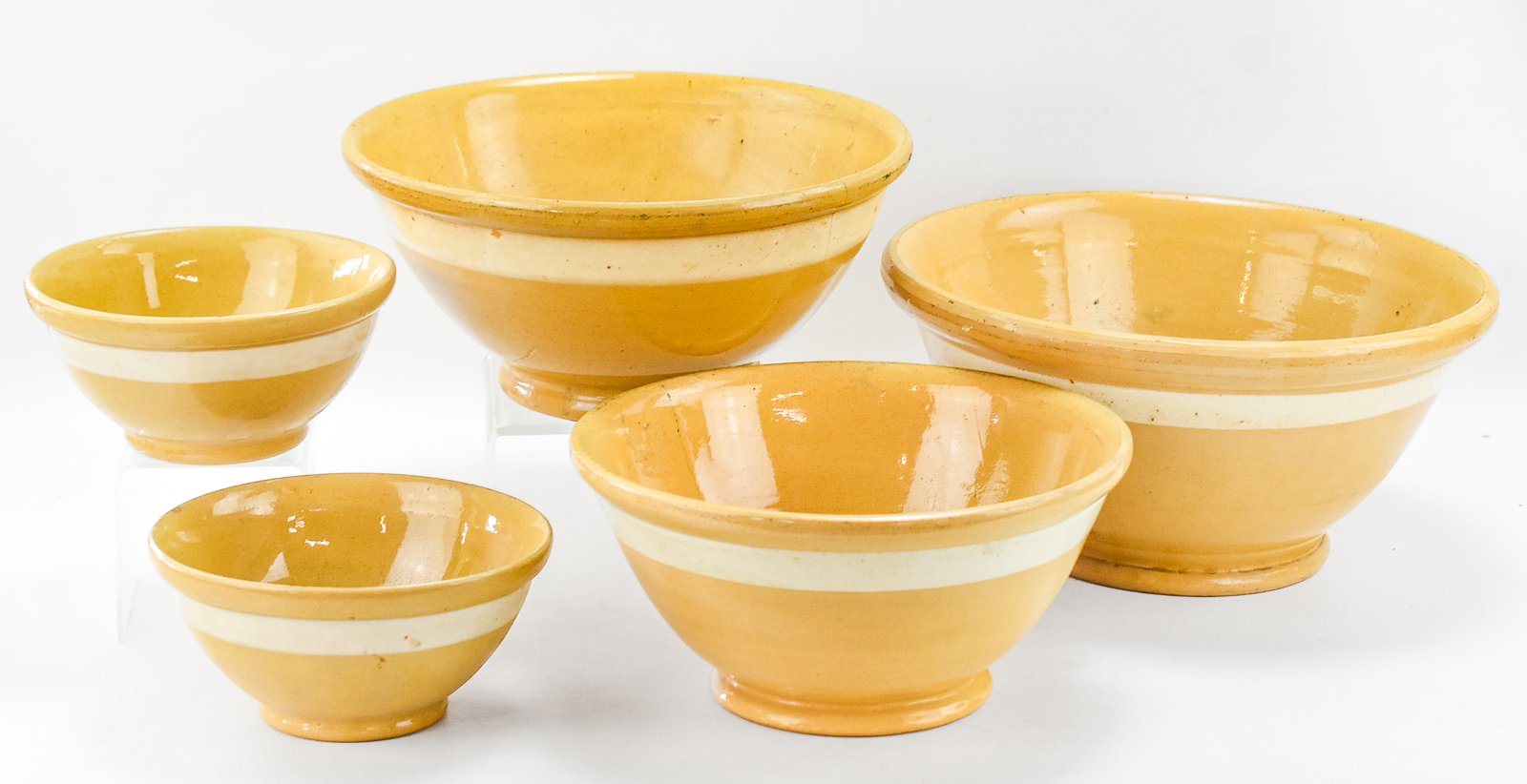 ASSORTMENT OF FIVE WHITE-BANDED YELLOW WARE BOWLS OF VARIOUS SIZES