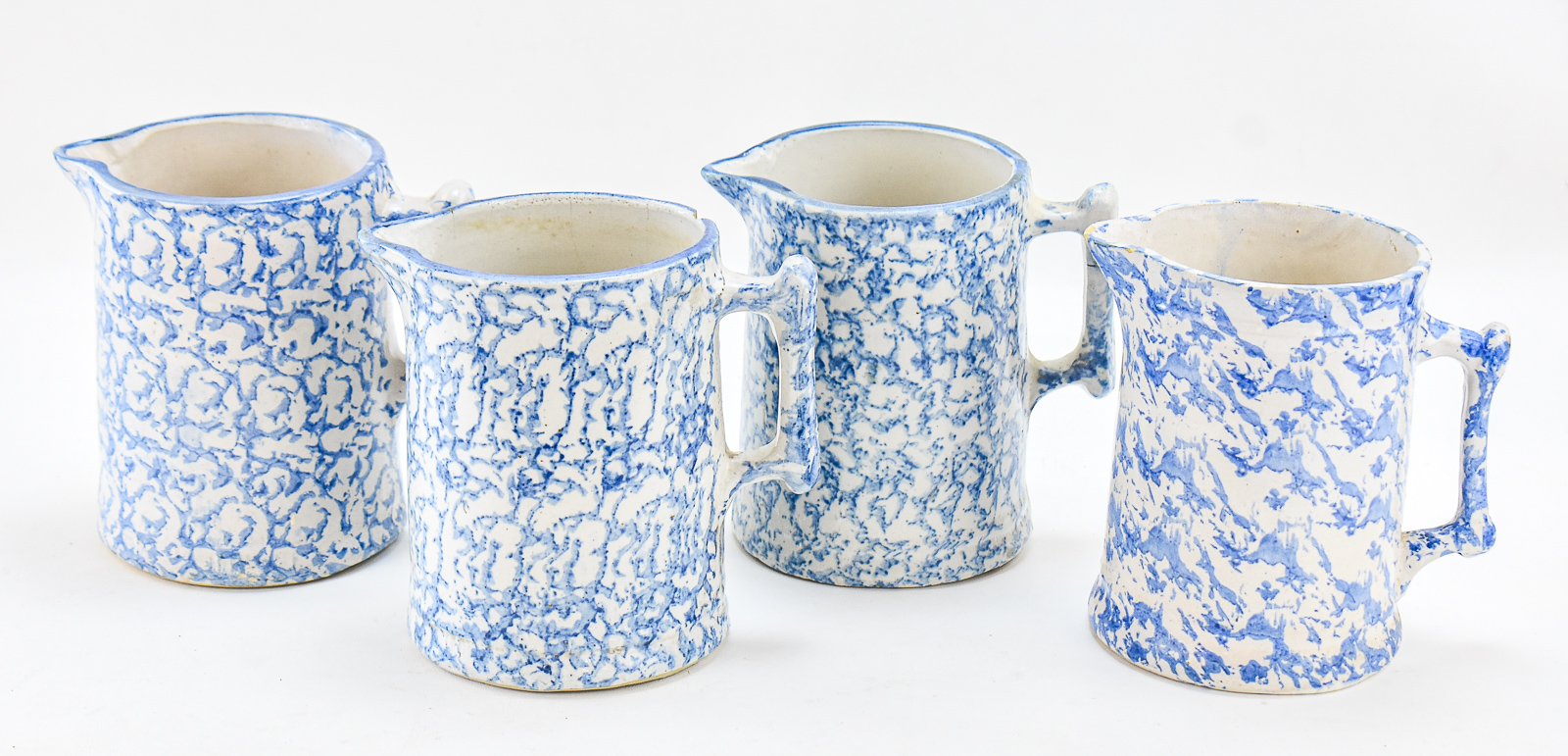 SET OF FOUR AMERICAN BLUE-AND-WHITE SPONGEWARE PITCHERS